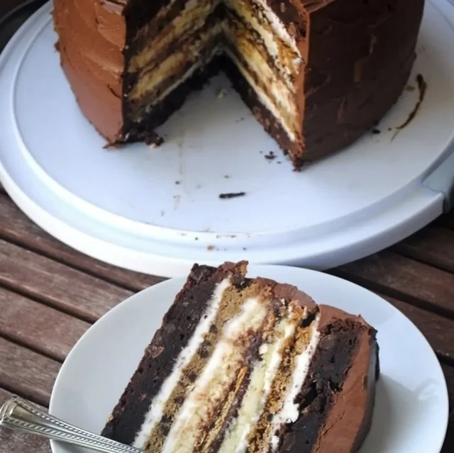 A layered chocolate cake slice under the evening lights