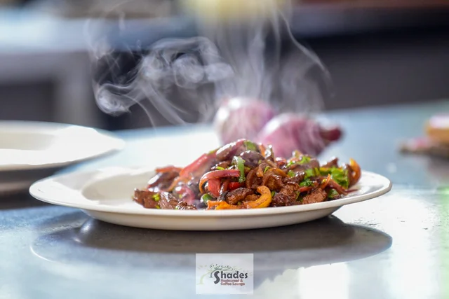 A steaming signature plate held fresh from the Shades kitchen